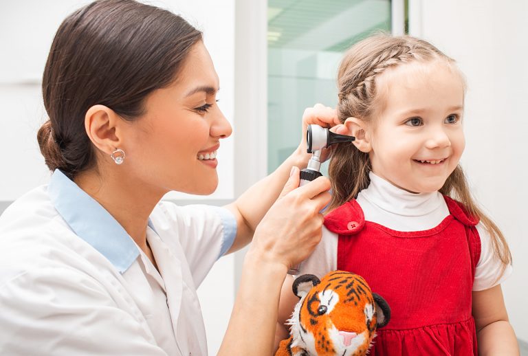 Médica observa o ouvido de criança